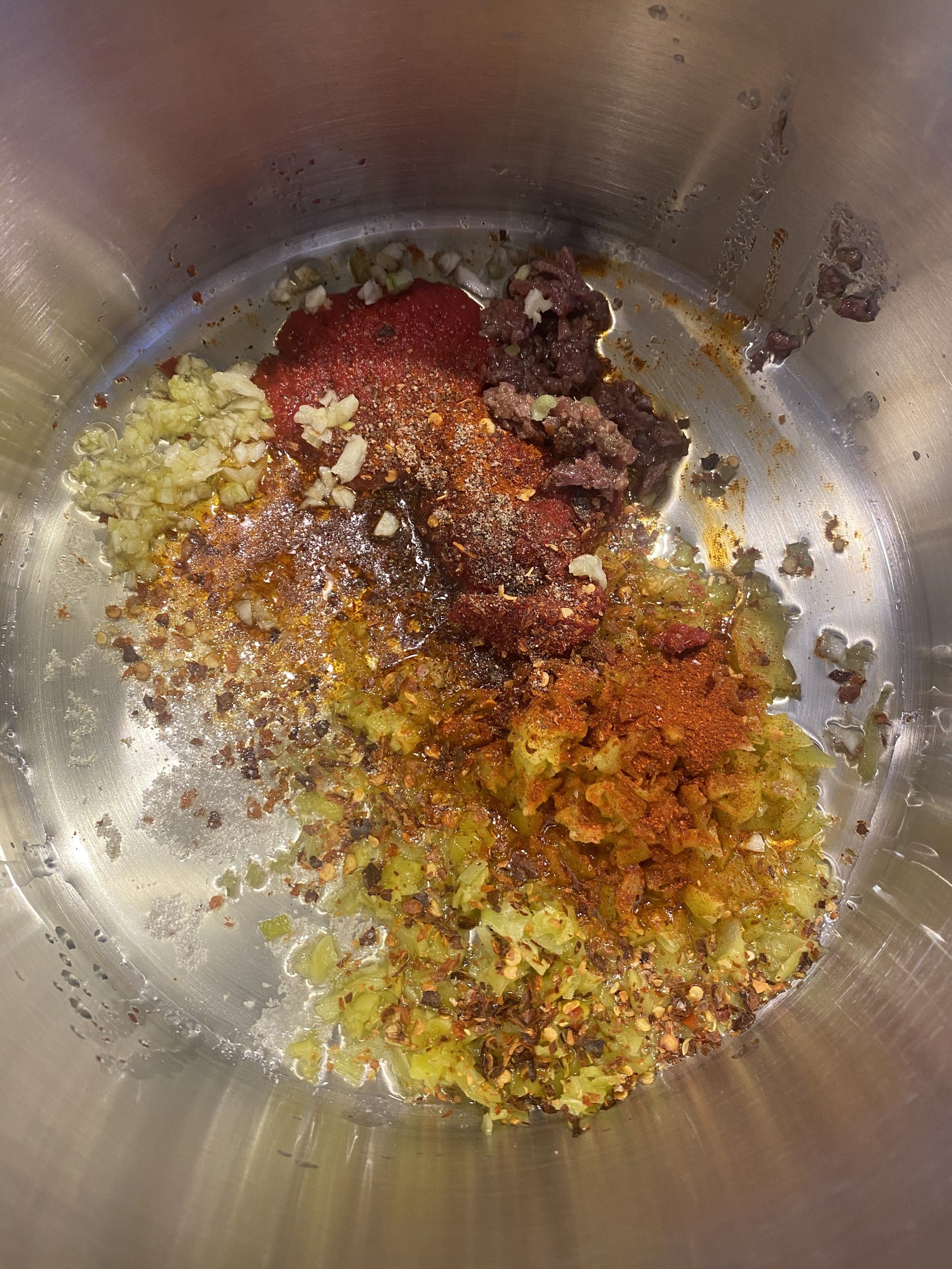 arrabbiata base in the bottom of a sauce pan: minced garlic, tomato paste, kosher salt, anchovies, paprika, cracked black pepper, red pepepr flakes, minced greek pepperocini